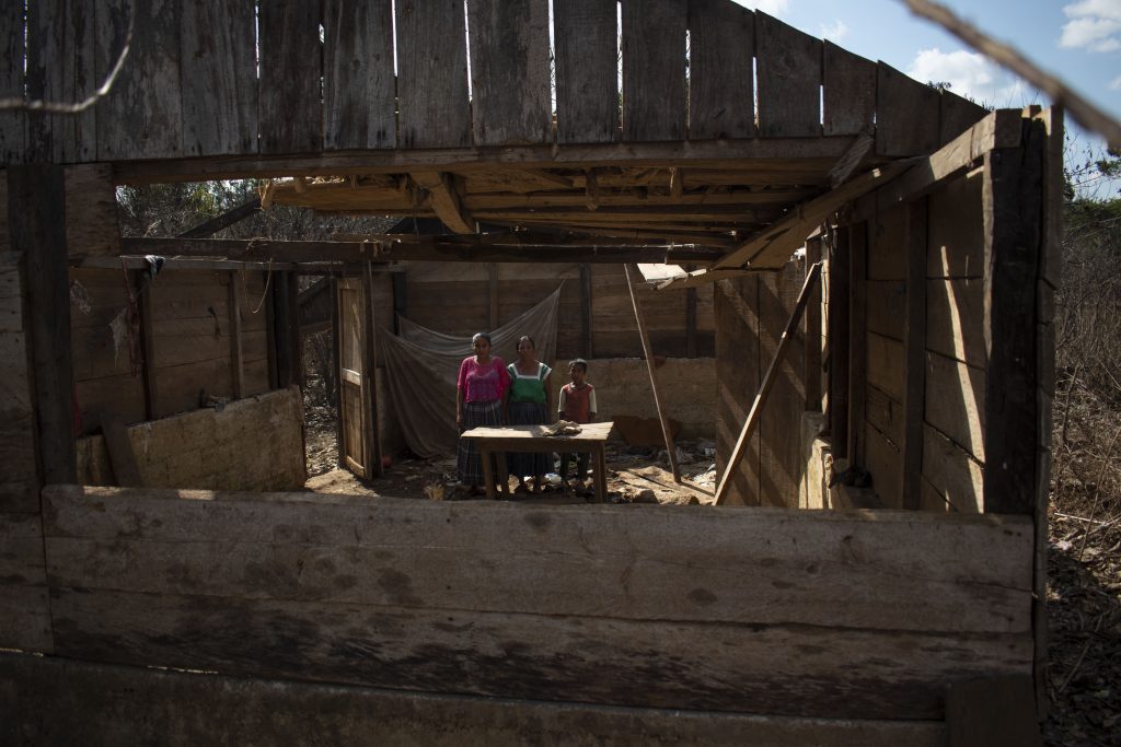 Adela Sacbá y sus dos hijos dentro de lo que queda de su vivienda. Fotografía: Carlos Alonzo